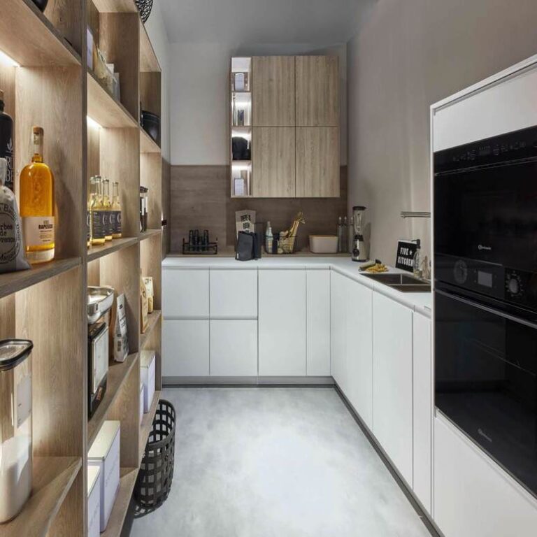 Moderne weiße Küche mit Hochschränken, Holzregal und schwarzen Einbaugeräten – Küche kaufen Aachen
